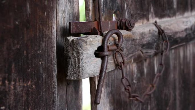 女性手用铁锁关闭旧木门