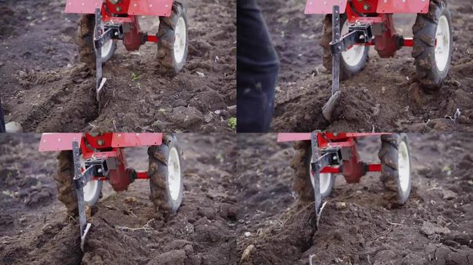 男子用耕作机准备花园土壤，有机家庭蔬菜农场的新播种季节。慢动作拍摄