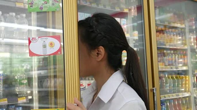 年轻女子在冷藏区购买冷藏食品