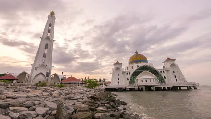 在马六甲海峡清真寺美丽的日出与移动和变化的彩云的延时4k镜头。向上倾斜。
