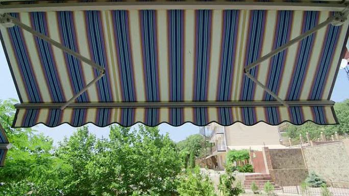 折叠式可伸缩遮阳篷安装在房屋的外墙上