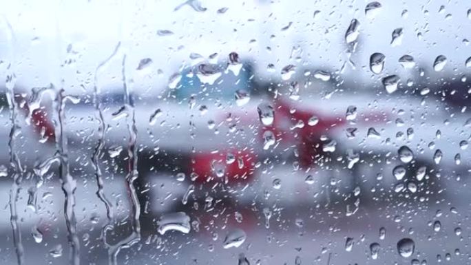 空中飞机窗户上的雨滴，外面模糊机场