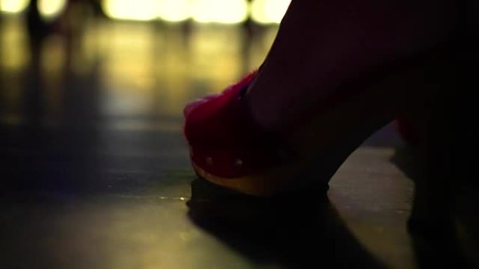 夜总会里一只穿着红色高跟鞋的女性脚的特写镜头。