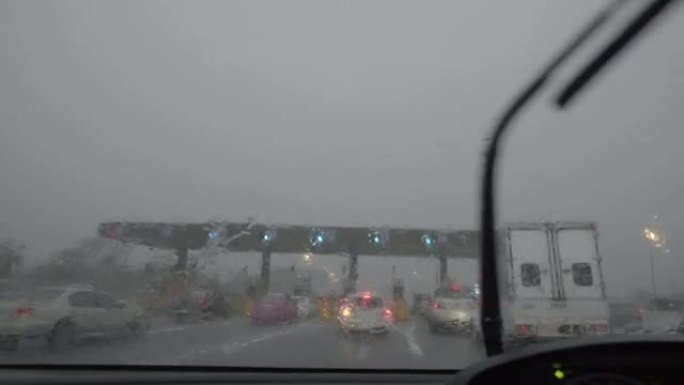 暴风雨期间，雨水在向高速公路收费时溅出了汽车挡风玻璃
