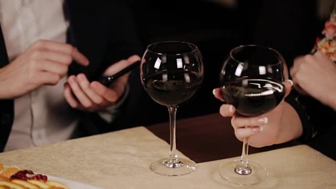 夫妻在餐厅喝酒，自己的智能手机