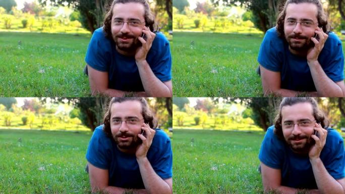 小伙子在草地上用手机说话