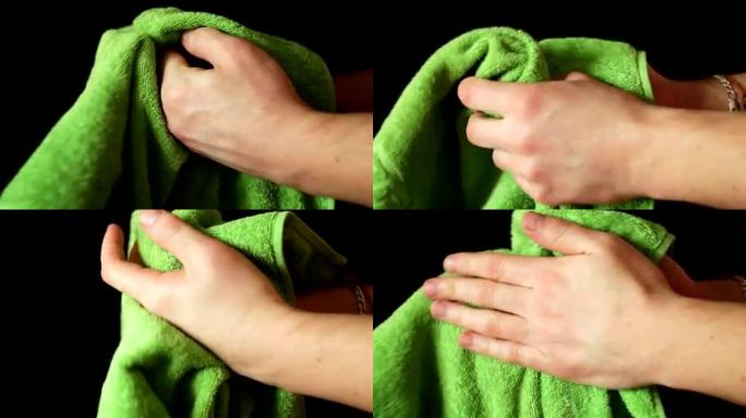 男人用绿色毛巾擦手。黑色背景