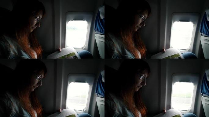 起飞期间在飞机上看书的女人