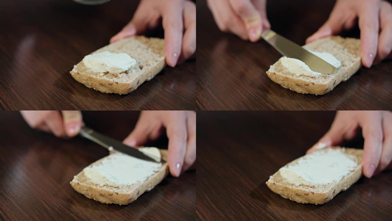女性的手在面包上撒上黄油