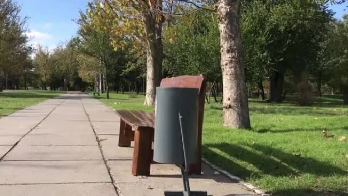 城市公园的木凳旁边的铁灰色骨灰盒