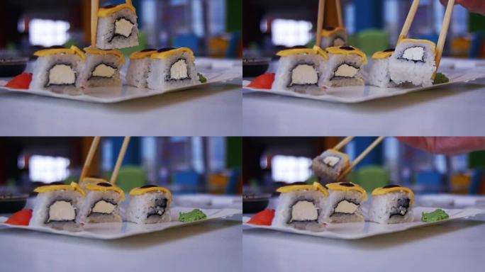 女人用筷子从日本餐馆的盘子里拿寿司