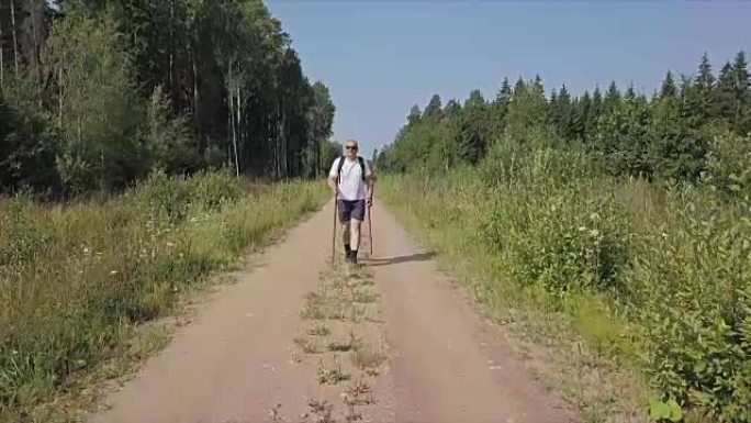 摄像机聚焦在森林路上的徒步旅行者上