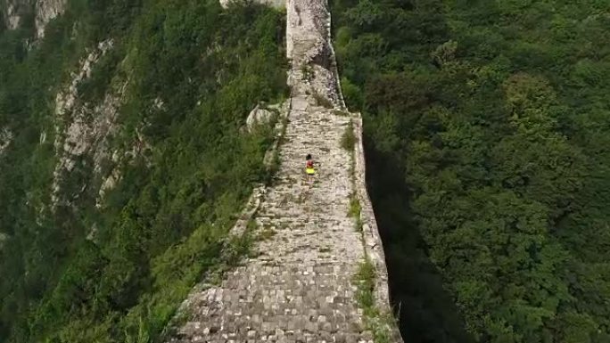 在长城顶上奔跑的年轻健身女子越野跑运动员的鸟瞰图