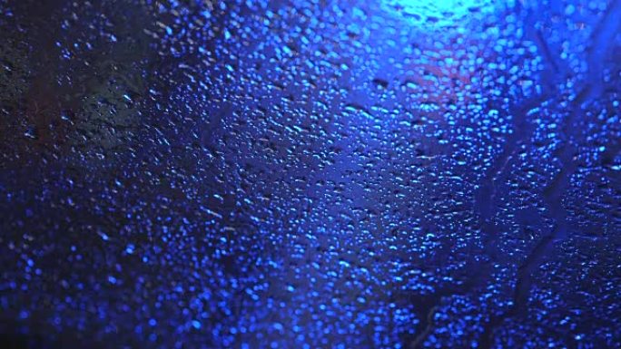 蓝色背景上挡风玻璃上的雨滴