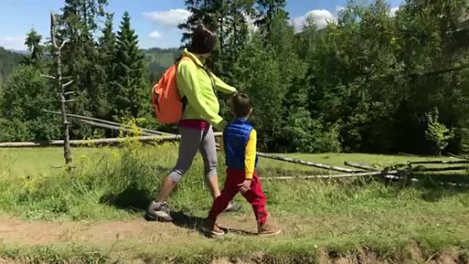 母亲和小儿子在山路上徒步旅行