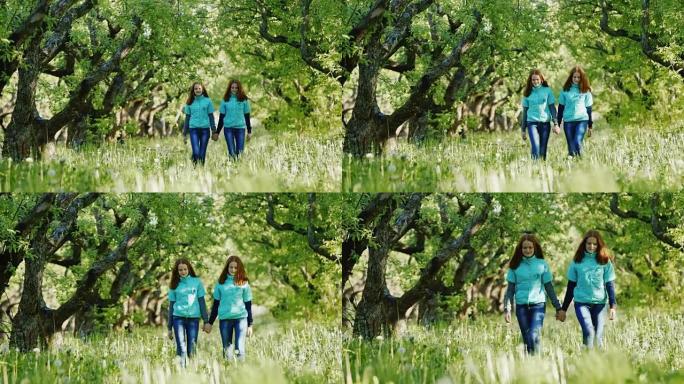 姐妹双胞胎一起走在苹果园