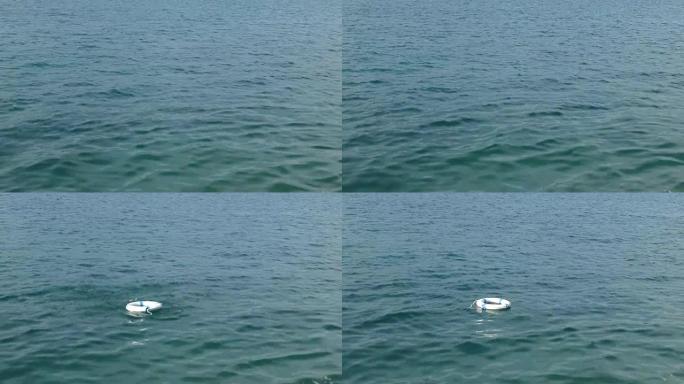一个白色的救援浮标被扔进水中并漂浮在水面上