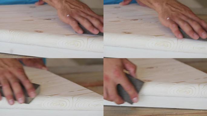 用砂纸打磨木步的男性双手特写