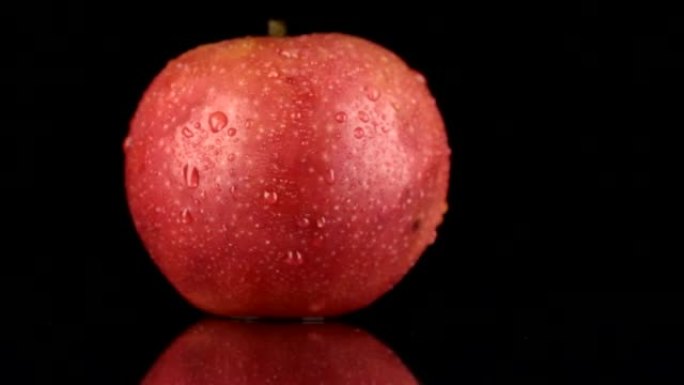 露珠中的红苹果在其轴上旋转