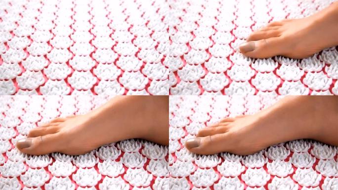女性脚踩针灸按摩垫。特写