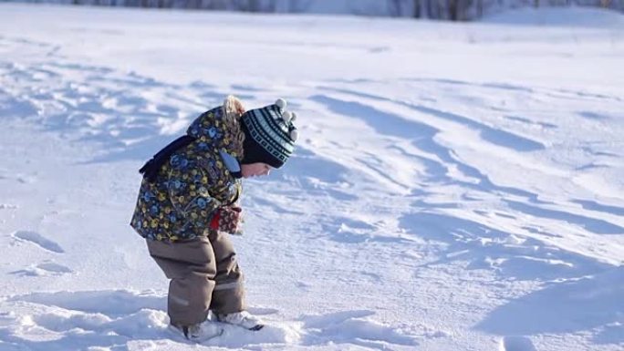 戴着冬帽的小男孩在雪地里玩耍