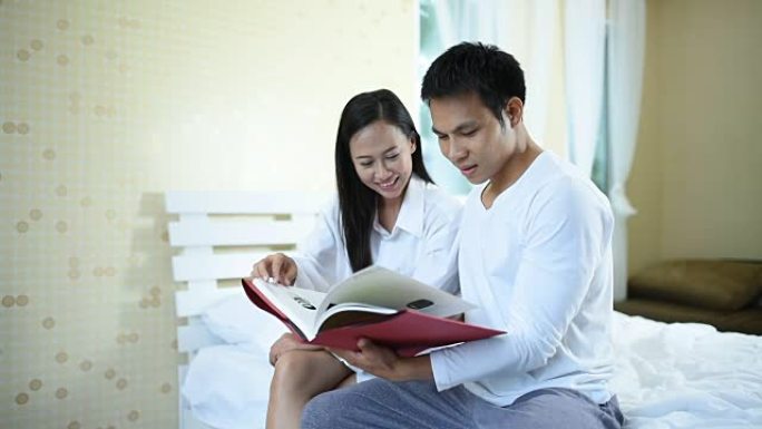 亚洲年轻夫妇在家里的房间里看书