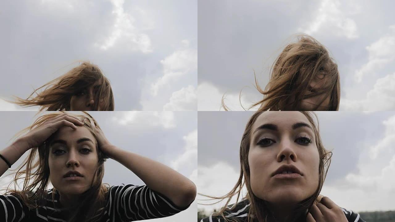 幸福的女人在慢动作中亲吻天空背景上的相机