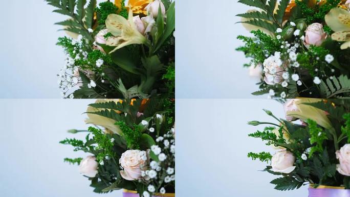 特写。花朵，花束，白色背景上的旋转，花卉组成由非洲菊，玫瑰介子形，绿叶，一枝黄花，满天星，蛛形纲组成