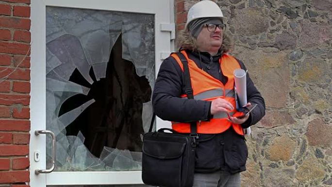 平板电脑在破窗附近的建筑检查员