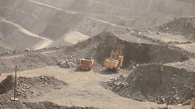 采石场的挖掘机和翻车机，大型黄色挖掘机将矿石装入翻车机
