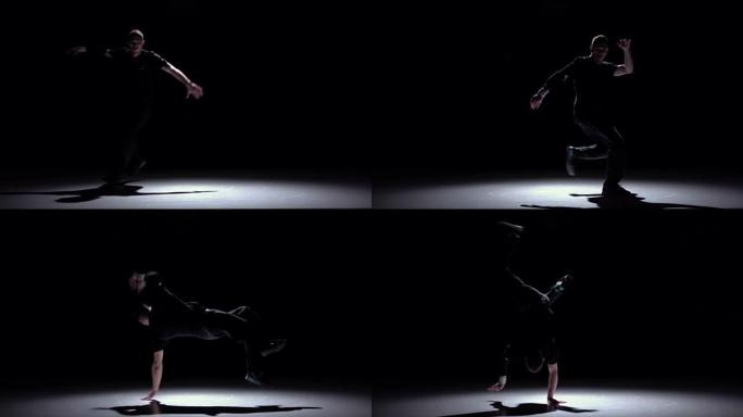 现代霹雳舞男子跳着手跳舞，黑色，阴影，慢动作