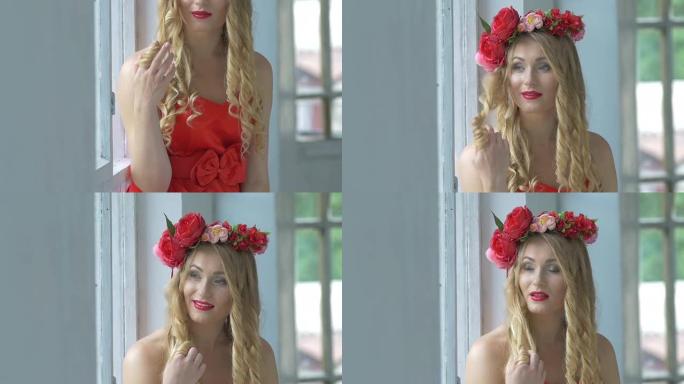 美丽的年轻女子头上戴着红花花环坐在窗台上，微笑着，凸轮向上移动，慢动作