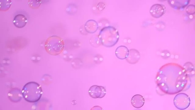 浅粉色、背景、慢动作上的蓝色透明肥皂泡