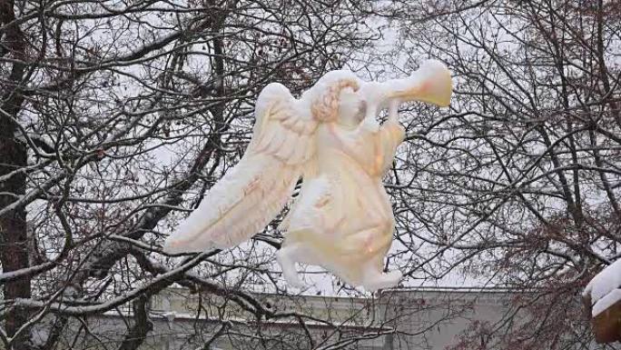 天使雕像剪影悬挂在圣诞节小镇的大雪中