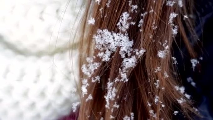 年轻女子戴着白帽子，围巾和头发上的雪