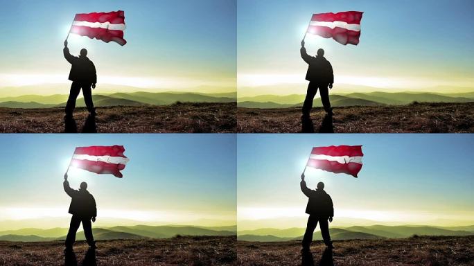 成功的剪影男子冠军挥舞拉脱维亚国旗山顶，Cinemagraph循环背景