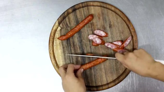 厨师在木制圆板上切Wienerwurst。顶视图。带加速的视频