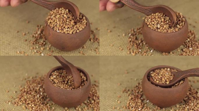 用勺子用手从旋转陶罐中倒出荞麦谷物