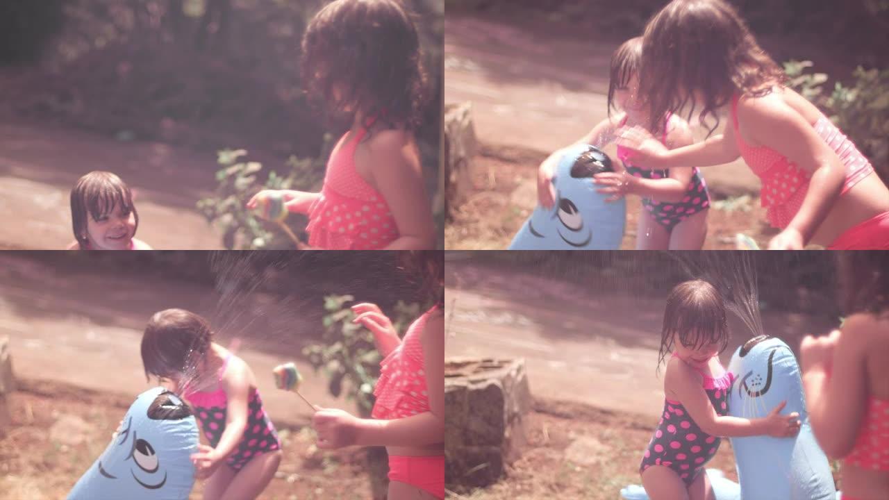 两个小女孩在洒水器外面玩耍