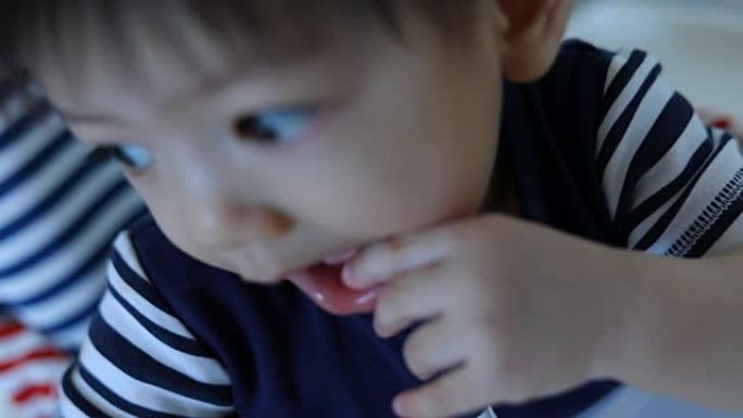 可爱的孩子宝宝用手指在嘴里发痒的口香糖，慢动作场景