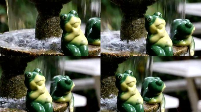 喷泉在公园里，摆放着一座可爱的青蛙雕像。
