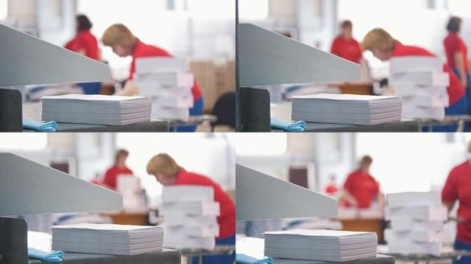 纸堆在从事排版工作的妇女面前-重点突出