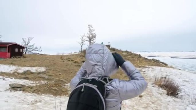 女人在贝加尔湖冰面上的旅行。闭关独特的佛塔布尔可汗纪念碑象征神秘的历史仪式岛大井山水山萨满教崇拜。冬