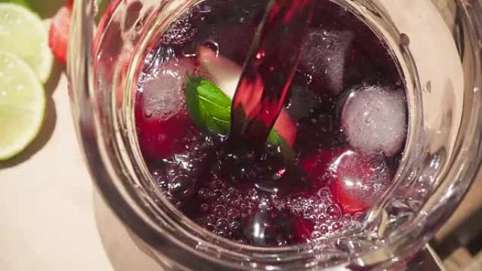 慢动作在装有冰和水果的水瓶中倒酒