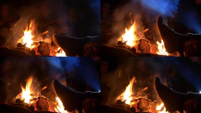 男人们的腿在篝火旁变暖进入夜林