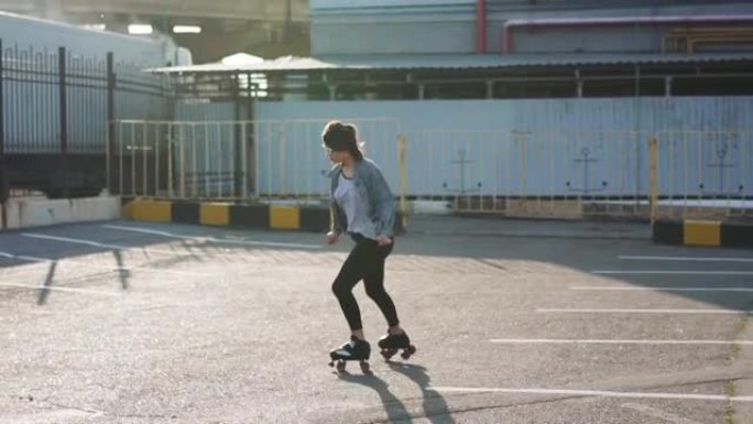 迷人美丽的年轻女子在街上溜冰跳舞。城市背景，慢动作120fps