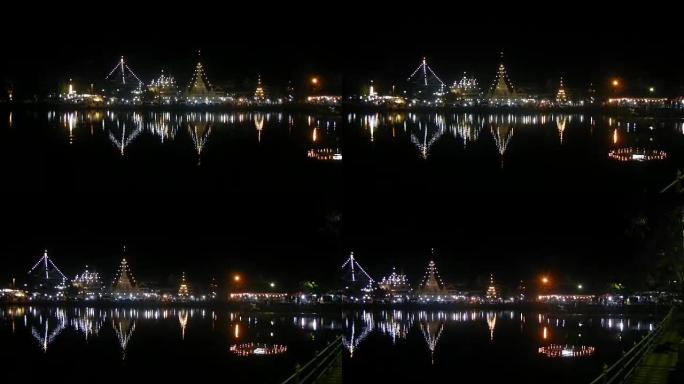 泰国小镇湖上的夜间寺庙反射灯。