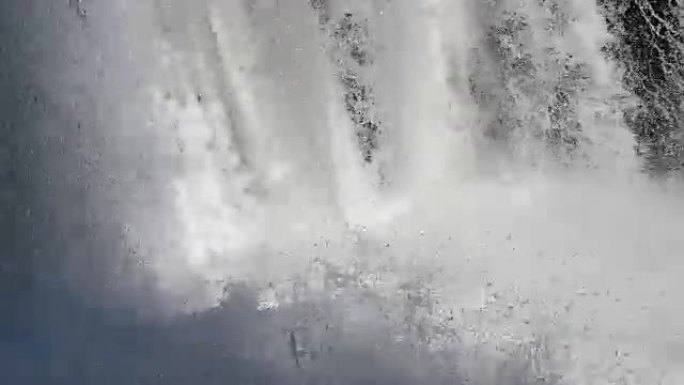 特写: 强大的汹涌白水瀑布坠落。清澈的冰川水流滴落。50fps