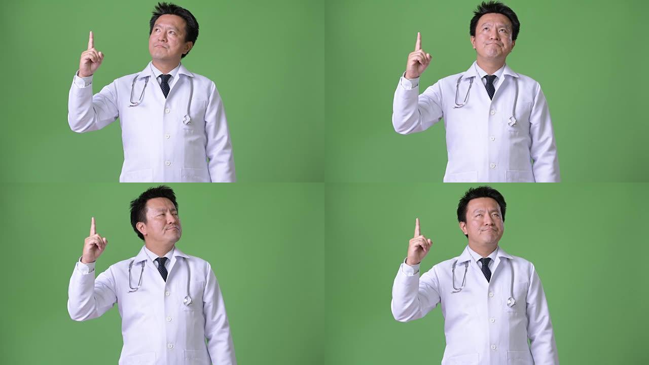 绿色背景下的成熟日本男人医生