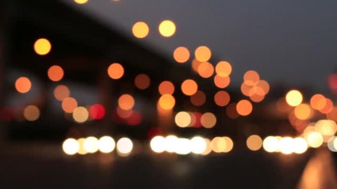 下雨后午夜街道上的灯光，光线背景的抽象圆形粒子，运动镜头模糊城市背景和夜晚的路灯